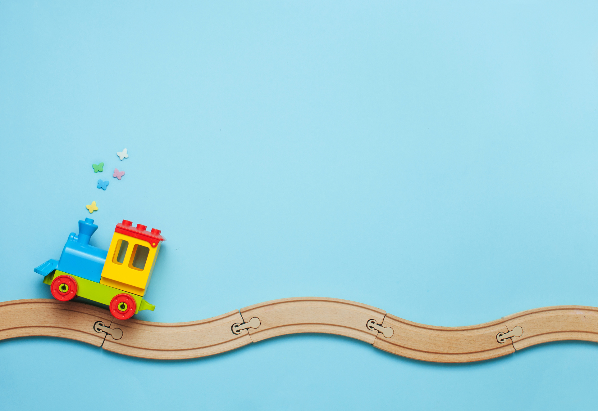 Kids train on toy wooden railway on blue background